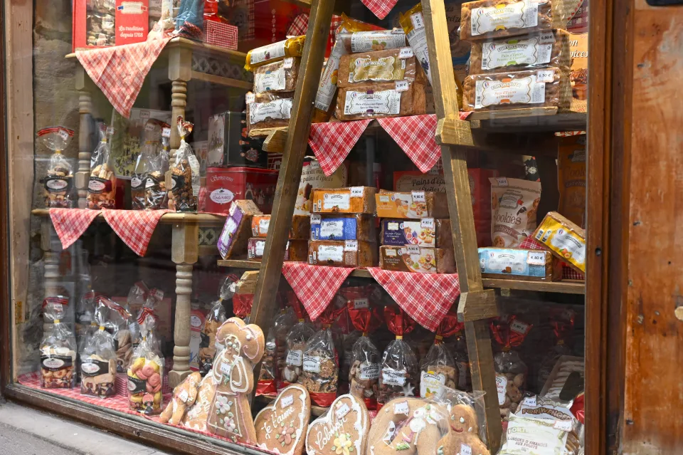 菓子や人形が並ぶ、赤いチェック柄で飾られた店のショーウィンドウ