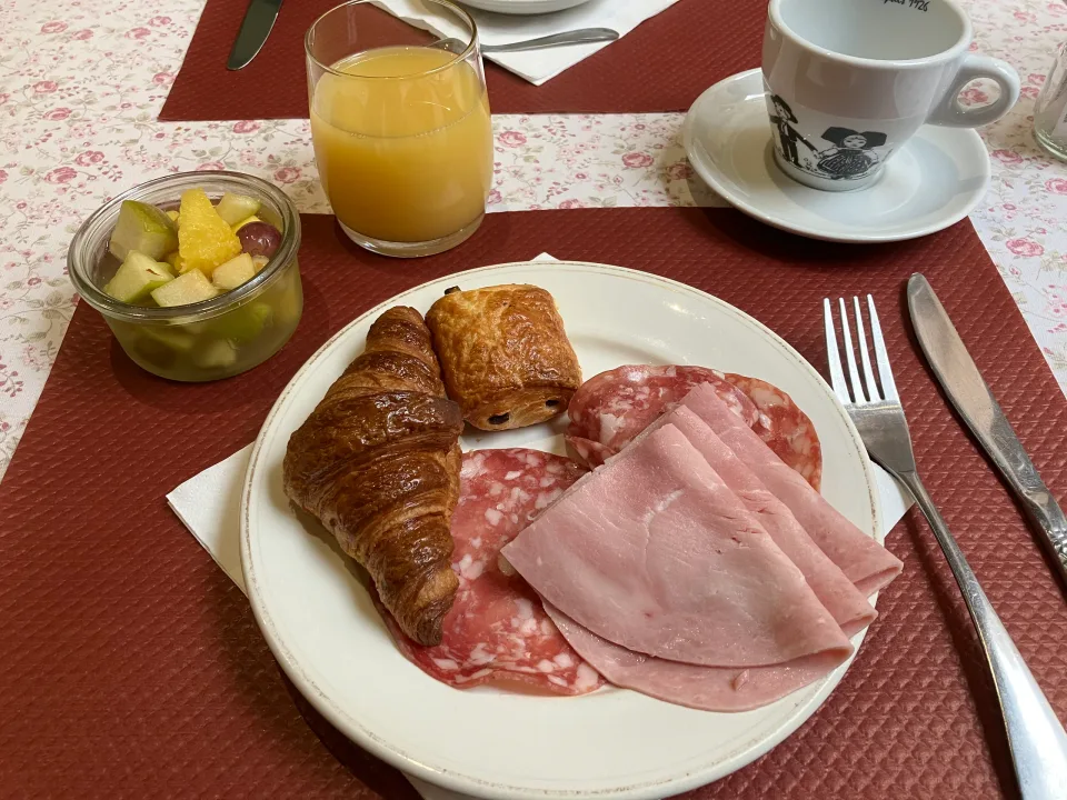 クロワッサン、ハム、サラミ、果物とオレンジジュースの朝食